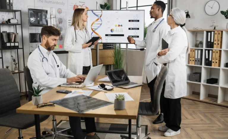 Doctors collaborating in a medical coworking space with a digital DNA presentation on screen.