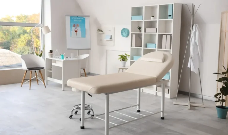 Bright and organized medical office space with an examination table, desk, anatomical poster, and shelving, ideal for clinical consultations